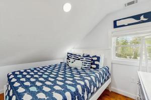 a bedroom with a bed with a blue and white comforter at Long Sands Serenity in York