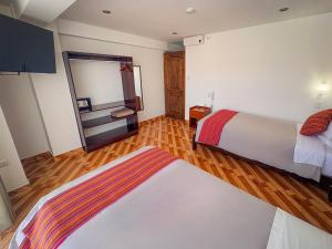 a hotel room with two beds and a mirror at Hotel Sky Mirador in Cusco