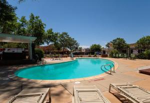 a swimming pool at a resort with tables and chairs at Parry Lodge in Kanab