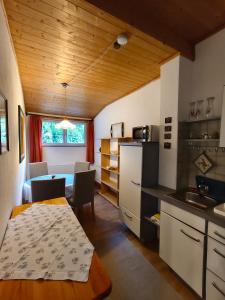 a kitchen with a table and a dining room at Blumenpension Strauss - Ferienwohnungen in Ossiach