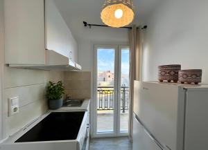 a kitchen with a sink and a refrigerator at Moussa Erato in Agia Anna Naxos