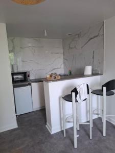 a kitchen with a counter and two stools at Flexygere 2 in Orléans