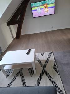 a living room with a white table and a tv at Flexygere 2 in Orléans +5 photos