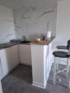 a kitchen with a counter and two chairs at Flexygere 2 in Orléans