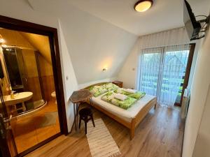 a bedroom with a bed and a bathroom at U Szaflarskich in Bańska Niżna