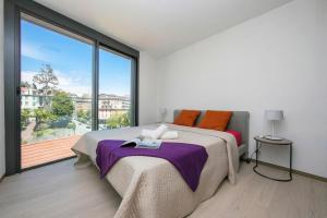 a bedroom with a bed and a large window at Urban Apartment Paradiso with Balcony and Parking - Happy Rentals in Paradiso