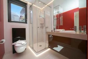 a bathroom with a toilet and a glass shower at Urban Apartment Paradiso with Balcony and Parking - Happy Rentals in Paradiso