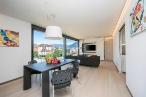 a dining room and living room with a table and chairs at Urban Apartment Paradiso with Balcony and Parking - Happy Rentals in Paradiso +6 photos