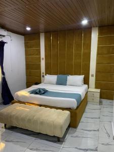 a bedroom with two beds and a bench in it at Perch Hotel & Suites in Lagos