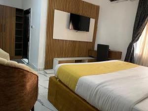 a bedroom with a bed and a tv on the wall at Perch Hotel & Suites in Lagos