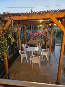a table and chairs under a wooden pergola at Vila Eriona in Baks-Rrjoll