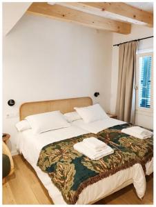 a bedroom with a bed with two towels on it at Hotelet Bastio 12 in Ciutadella