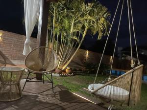 a couple of chairs sitting on a patio at night at Espaço da Mariah in Arroio do Meio