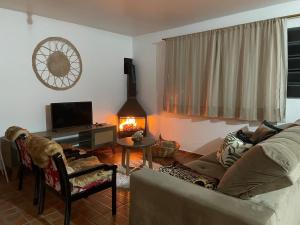 a living room with a dog sitting on a chair and a couch at Espaço da Mariah in Arroio do Meio
