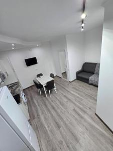 a living room with a table and chairs and a couch at Small House ApartHotel in Chişinău