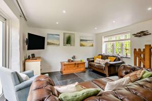 a living room with leather furniture and a flat screen tv at 3 Bed in Croyde oc-beren in Croyde