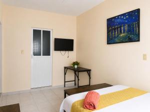 a bedroom with a bed and a tv on the wall at Casa Dolores in Dolores Hidalgo