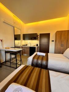 a hotel room with two beds and a kitchen at Railway Studio 1 - Cozy Studio in Byblos - Central Location in Jbeil