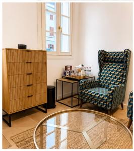 a living room with a chair and a glass table at Hotelet Bastio 12 in Ciutadella