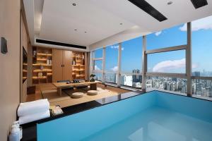 a swimming pool in a room with a large window at Changsha Rama-da by Wyndham Wuyi Square-Near Metro-Business Center in Changsha
