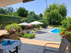 a patio with tables and umbrellas and a swimming pool at Casa Cabarceno Piscina y Barbacoa in Bofetán