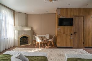 a bedroom with a fireplace and a table and chairs at Tashrabat Hotel in Karakol