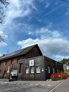 a large wooden building with a sign on it at Race & Rest Apartments in Baar