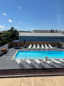 a swimming pool with white lounge chairs at Shore Point Motel in Point Pleasant Beach
