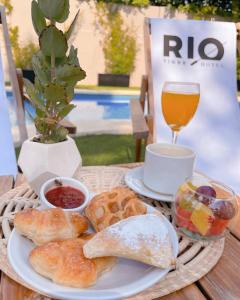 a plate of bread and a cup of coffee and a drink at RIO TIGRE HOTEL in Tigre