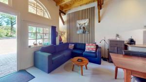 a living room with a blue couch and a table at Vakantie appartement Erve de Wezel in Diepenheim