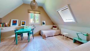 a attic room with a table and a window at Vakantie appartement Erve de Wezel in Diepenheim