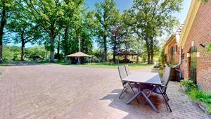 a table and chairs sitting next to a building at Vakantie appartement Erve de Wezel in Diepenheim