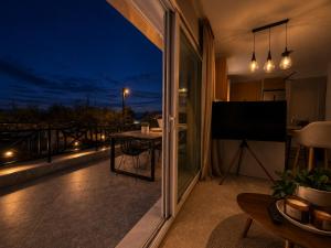 a view of a balcony at night with a television at Aura Residence Beachfront by Horizon Homes in Ofrínion +16 photos