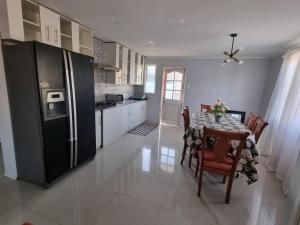 a kitchen with a table and a black refrigerator at Casa campo Quillota in Quillota