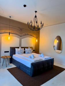 a bedroom with a large bed and a chandelier at Demiani House in Sibiu