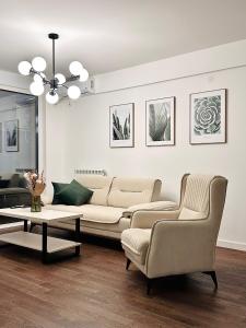 a living room with a couch and two chairs and a table at Tesla Palace III in Kragujevac