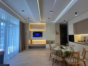 a dining room with a table and a television on a wall at Sea Breeze Polo in Nardaran
