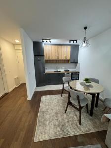 a living room with a table and a kitchen at Tesla Palace III in Kragujevac