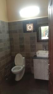 a bathroom with a toilet and a sink and a mirror at The Aalayam in Mukteshwar +24 photos