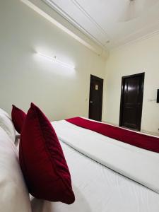 a bedroom with a large bed with red pillows at Hotel Rs Inn - 5 Mints Walk From New Delhi Railway Station And Connaught Place in New Delhi