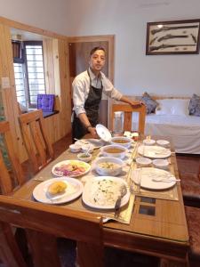 a man standing in front of a table full of food at The Aalayam in Mukteshwar