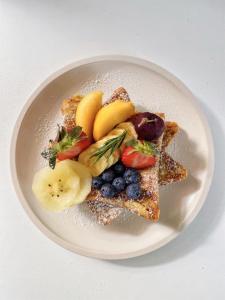 a plate of food with toast and fruit on it at Hotel Rs Inn - 5 Mints Walk From New Delhi Railway Station And Connaught Place in New Delhi