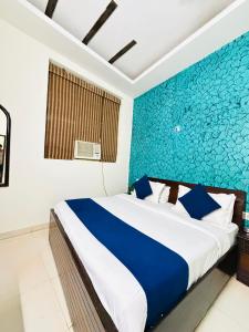 a bedroom with a bed with a blue accent wall at Hotel Rs Inn - 5 Mints Walk From New Delhi Railway Station And Connaught Place in New Delhi