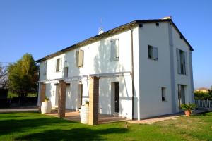 Casa blanca con ventanas y patio en il leccio, en San Lazzaro di Savena