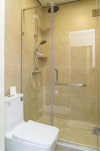 a bathroom with a glass shower with a toilet at Tashrabat Hotel in Karakol