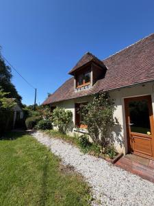 a white house with a wooden door and a yard at Le Clos du Avre - Maison calme & jardin verdoyant in Breux-sur-Avre