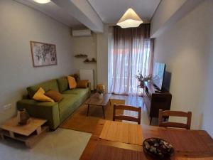 a living room with a green couch and a table at Anelia in Nea Artaki