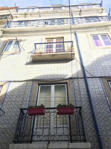 a building with two windows and a balcony at Casa dos Mastros in Lisbon