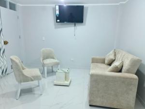 a living room with a couch and two chairs and a tv at Montecarlo Hospedaje in Tacna +7 photos