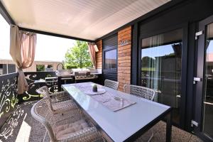 a dining room with a table and chairs on a balcony at L&A Mobile House in Metlika